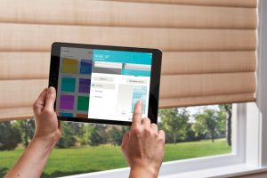 person using Hunter Douglas app on tablet to control blinds